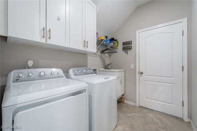 clothes washing area with light tile patterned flooring, cabinets, separate washer and dryer, and a textured ceiling