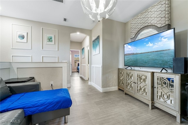 bedroom featuring an inviting chandelier and light wood-type flooring