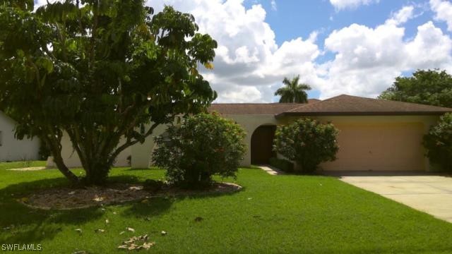 view of front of property featuring a garage and a front lawn