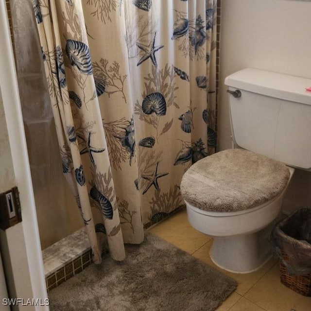 bathroom featuring tile patterned floors, a shower with curtain, and toilet