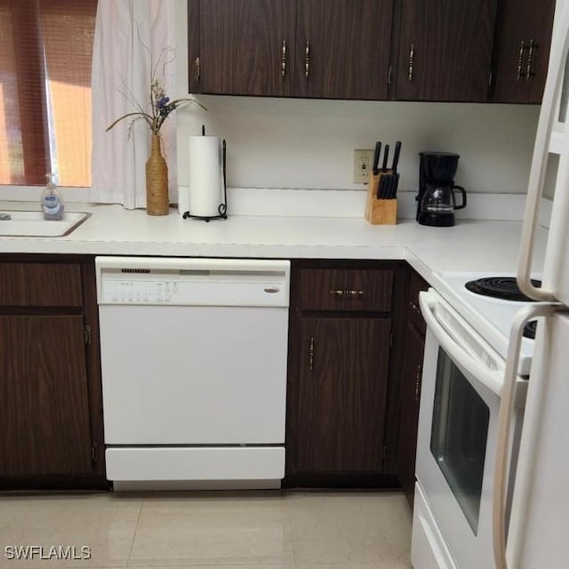 kitchen with light tile patterned floors, white appliances, and dark brown cabinetry