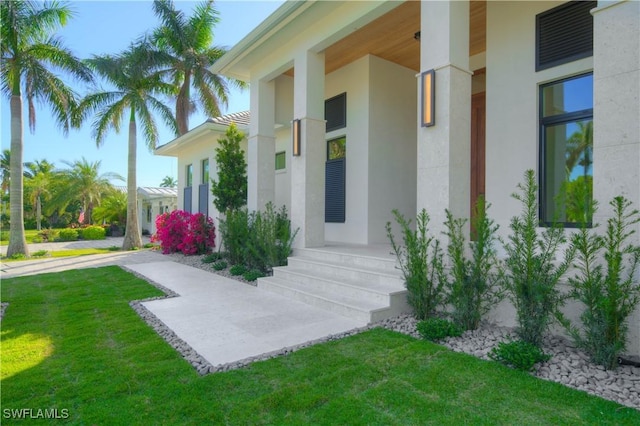 entrance to property featuring a lawn