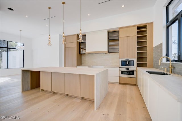 kitchen with sink, decorative light fixtures, decorative backsplash, and a center island