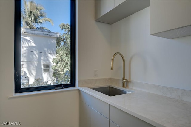 kitchen featuring white cabinetry and sink