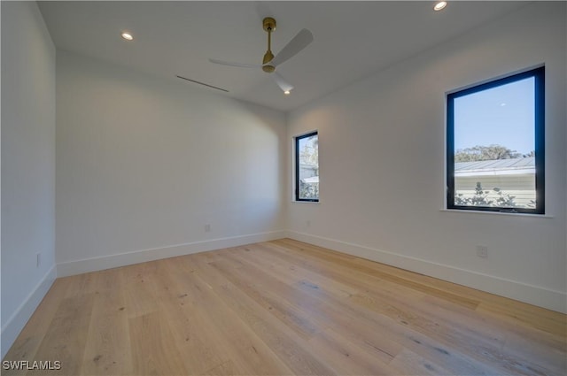 unfurnished room featuring ceiling fan, light hardwood / wood-style flooring, and a wealth of natural light