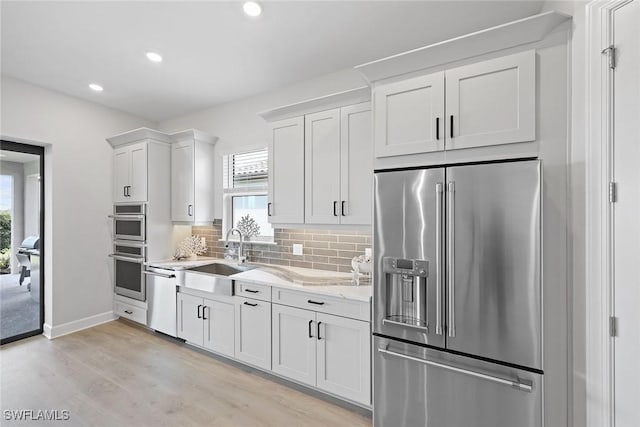 kitchen featuring a wealth of natural light, sink, white cabinets, and stainless steel appliances