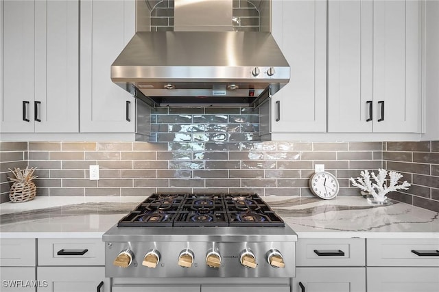 kitchen featuring white cabinets, wall chimney range hood, backsplash, and stainless steel gas cooktop