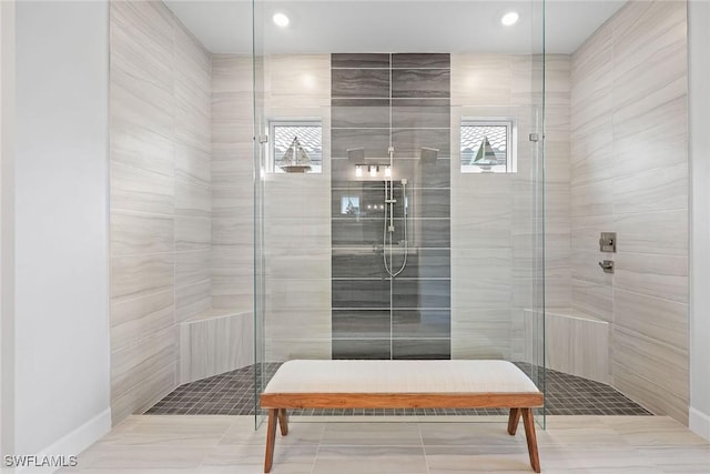 bathroom featuring a tile shower, a wealth of natural light, and tile patterned floors