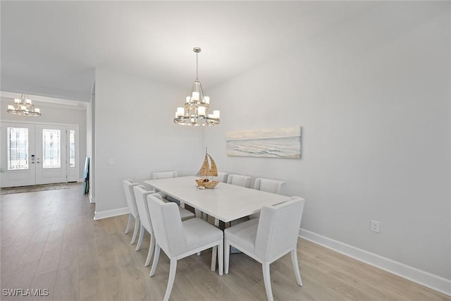 dining space featuring a chandelier, french doors, and light hardwood / wood-style floors