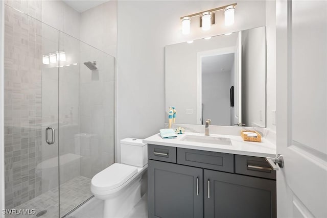 bathroom with vanity, toilet, and a shower with shower door