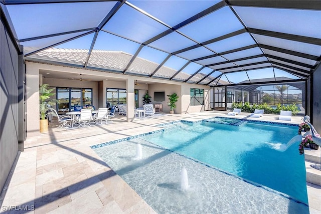 view of pool with pool water feature, glass enclosure, and a patio