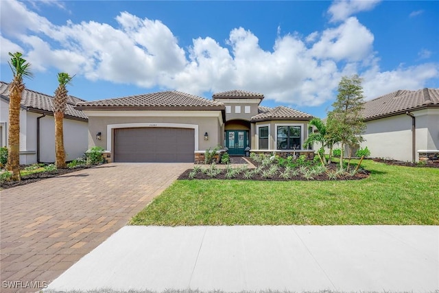 mediterranean / spanish house with a garage and a front yard