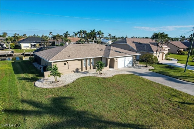 view of front of property featuring a water view, a garage, and a front lawn