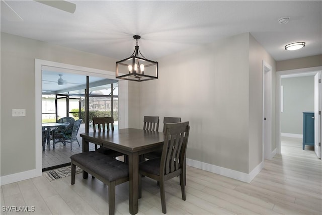 dining space with light hardwood / wood-style flooring and ceiling fan with notable chandelier