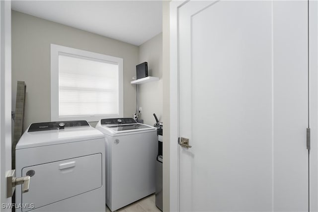 laundry area with washer and clothes dryer and light hardwood / wood-style flooring