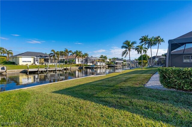 view of dock featuring a lanai, a lawn, and a water view