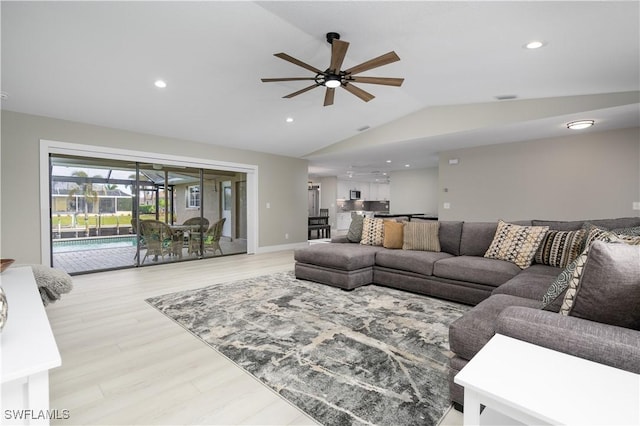 living room with light wood-type flooring, vaulted ceiling, and ceiling fan