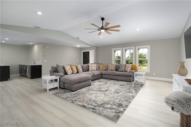 living room featuring ceiling fan, light hardwood / wood-style floors, lofted ceiling, and sink