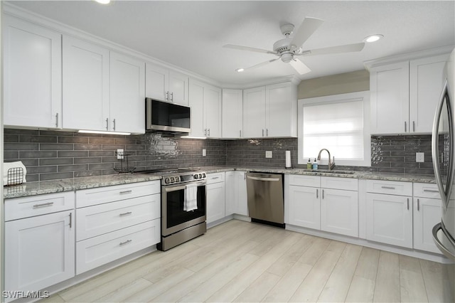 kitchen with light hardwood / wood-style floors, sink, white cabinetry, and stainless steel appliances