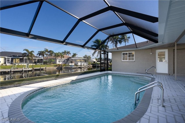 view of pool with a lanai, a patio area, and a water view