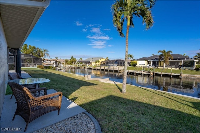 view of yard with a lanai and a water view