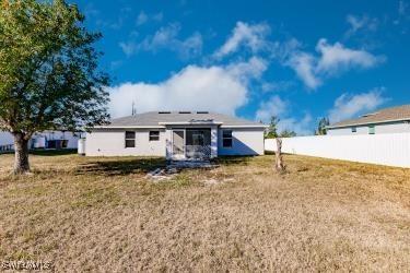 back of house featuring a lawn