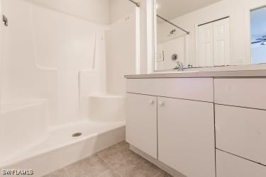 bathroom featuring tile patterned floors, vanity, and a shower