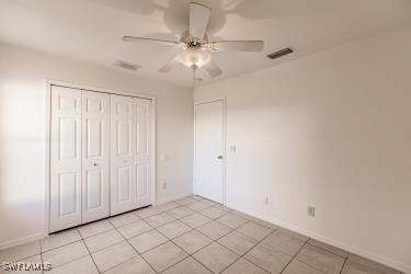 unfurnished bedroom featuring ceiling fan, a closet, and light tile patterned floors