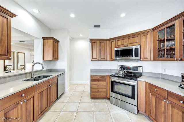 kitchen with appliances with stainless steel finishes, light tile patterned floors, and sink