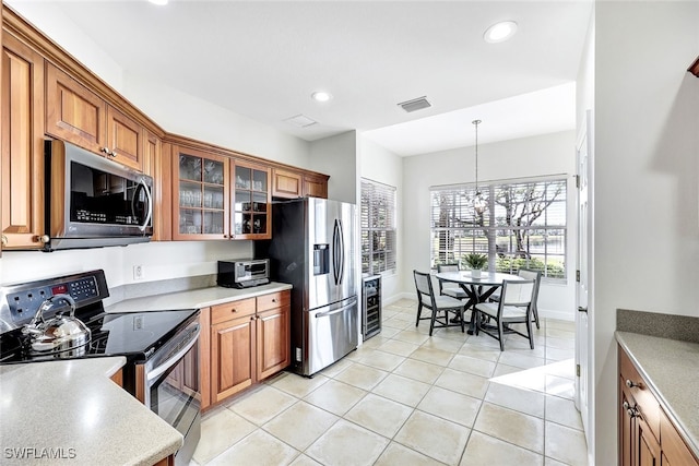 kitchen with appliances with stainless steel finishes, pendant lighting, a notable chandelier, wine cooler, and light tile patterned flooring