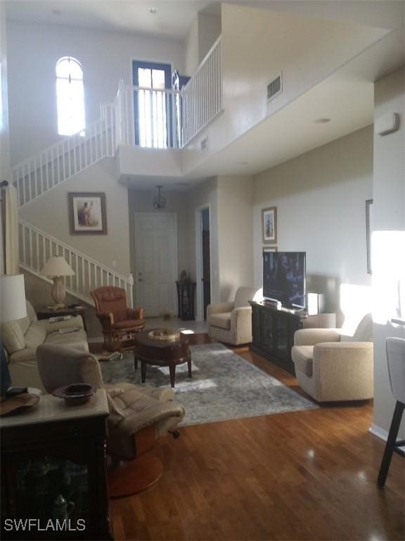 living room featuring hardwood / wood-style floors and a towering ceiling