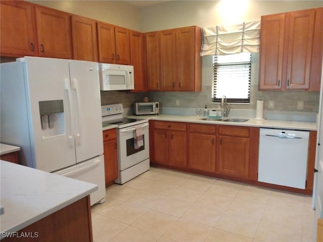 kitchen with backsplash, white appliances, and sink