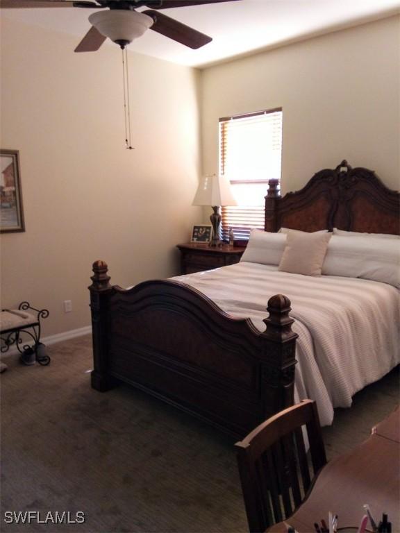 bedroom with ceiling fan and dark carpet