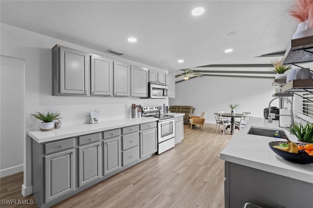 kitchen featuring gray cabinetry, light hardwood / wood-style floors, ceiling fan, and appliances with stainless steel finishes