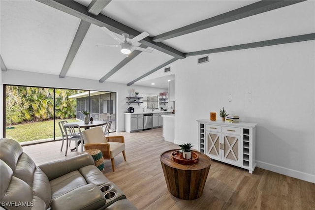 living room with ceiling fan, wood-type flooring, and vaulted ceiling with beams