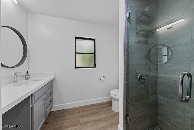 bathroom with walk in shower, vanity, toilet, and wood-type flooring