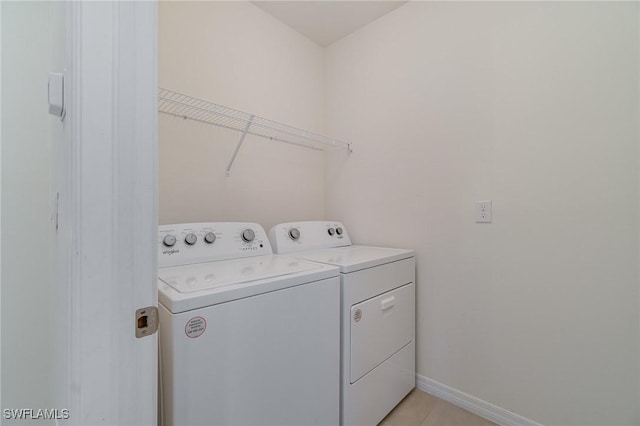 laundry area featuring washer and clothes dryer and light tile patterned flooring