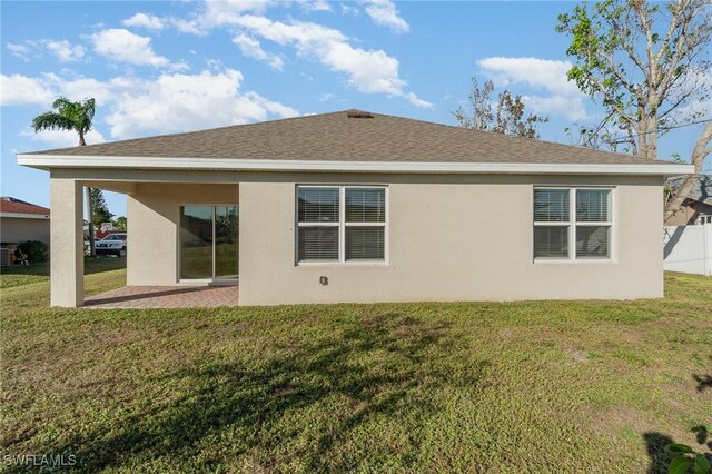 rear view of house with a lawn and a patio area