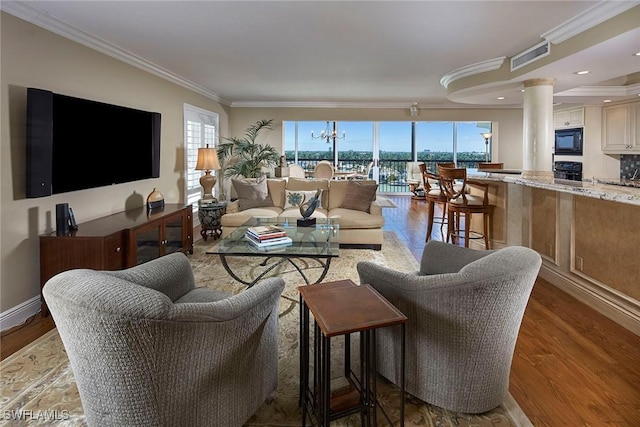 living room featuring crown molding, plenty of natural light, and hardwood / wood-style floors