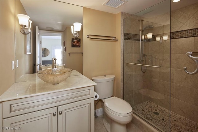 bathroom featuring vanity, a shower with door, and toilet