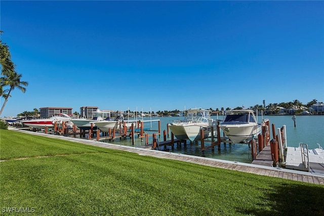 view of dock with a lawn and a water view