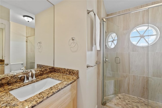 bathroom with vanity, toilet, and walk in shower