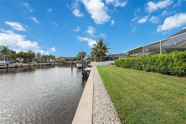 view of dock with a yard, a water view, and glass enclosure