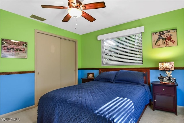 bedroom with light colored carpet, a closet, and ceiling fan