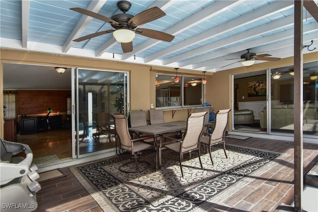 sunroom / solarium featuring beamed ceiling and ceiling fan