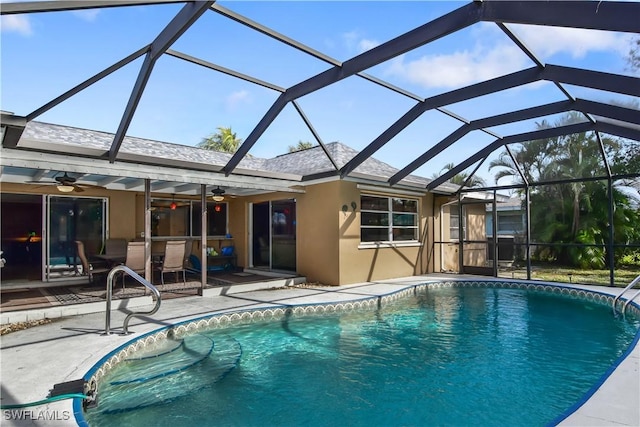 view of pool featuring glass enclosure, ceiling fan, and a patio area