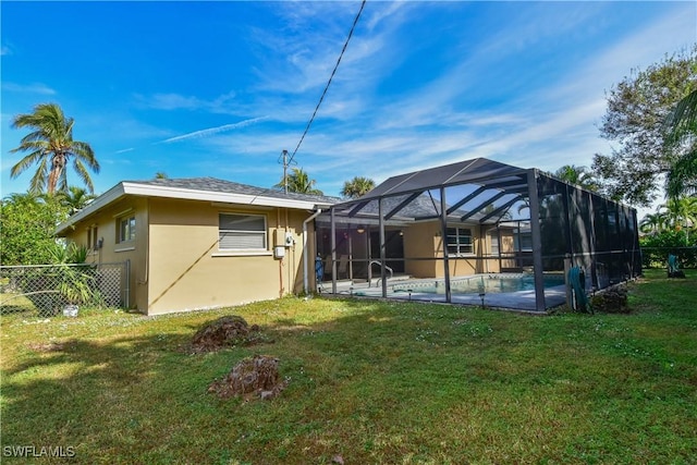 rear view of property with a lanai, a fenced in pool, and a yard