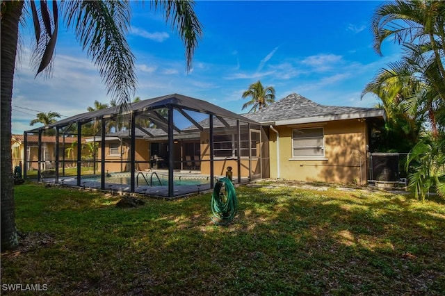 back of property featuring a lanai and a yard