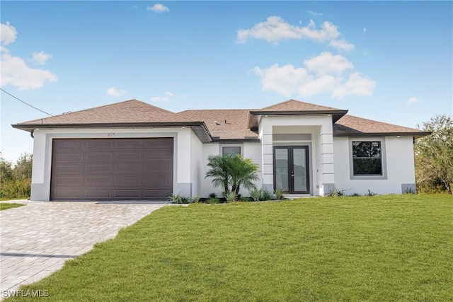 view of front of house featuring french doors, a garage, and a front lawn