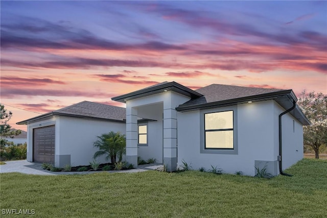 view of front of property with a garage and a yard